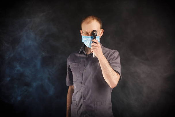 young doctor in a mask in smoke - Photo, image
