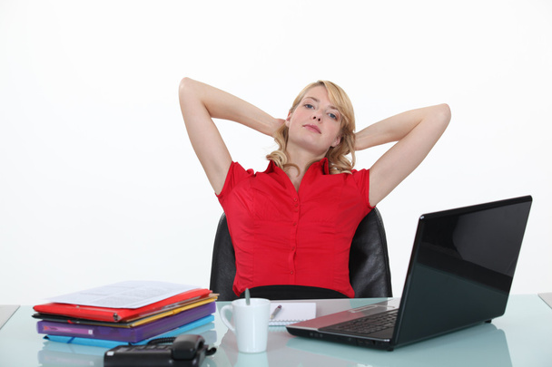 Blond woman relaxing at her desk - Foto, imagen