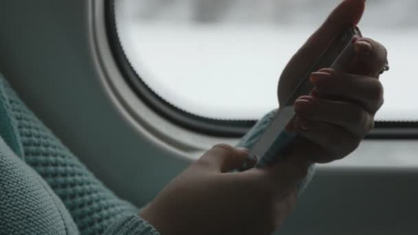 Mladá žena na cestách ve vlaku a pomocí mobilního telefonu. Ženská ruka odešle zprávu od smartphone. Rameno dívky chatování s přáteli. Detailní záběr - Záběry, video
