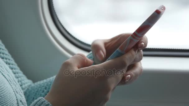 Jonge vrouw reizen in een trein en het gebruik van de mobiele telefoon. Vrouwelijke hand stuurt een bericht van de smartphone. Arm meisje chatten met vrienden. Close-up - Video