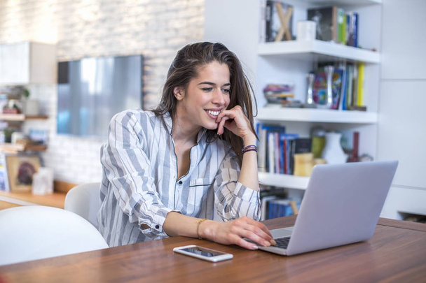 Young woman working on laptop at home - Photo, image