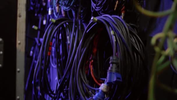 Kable elektryczne dla urządzeń dźwiękowych są skręcone, wiszące na ścianie w biurze techników dźwięku. Koncert rockowy za kulisami przewody i kable. - Materiał filmowy, wideo