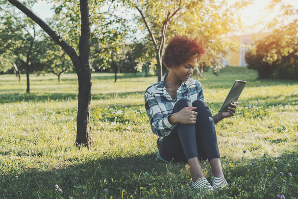 Mixed girl with digital tablet in park - Foto, Imagen