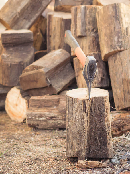 Um machado com uma alça laranja e uma grande pilha de bloco de madeira de madeira
. - Foto, Imagem