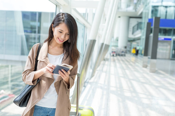 Femme vérifiant sur téléphone portable à l'aéroport de Hong Kong
  - Photo, image