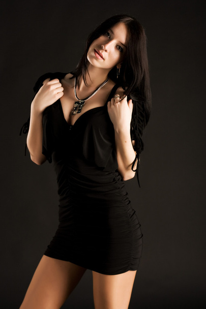 Beautiful young woman in black dress - Fotó, kép