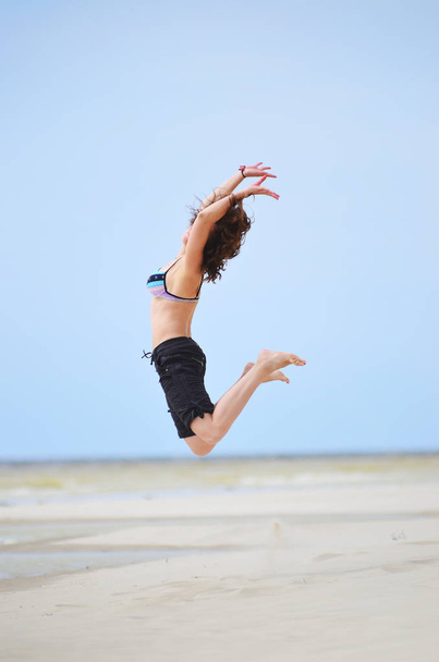Girl jumping on the seashore - Fotografie, Obrázek