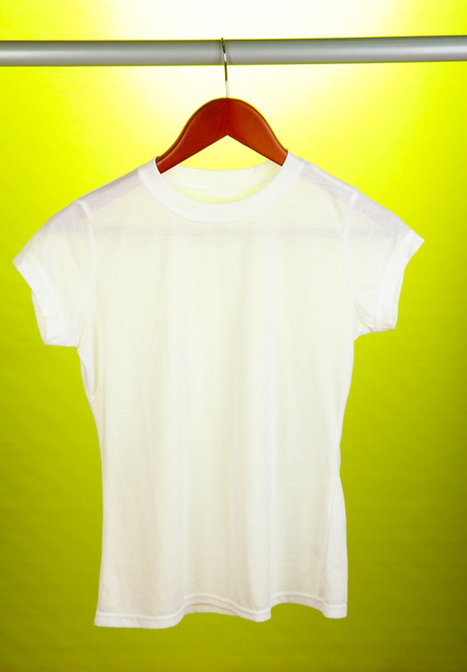 White t-shirt on hanger on yellow background - Фото, зображення