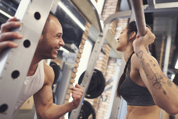 Happy couple working out with barbell - Photo, Image