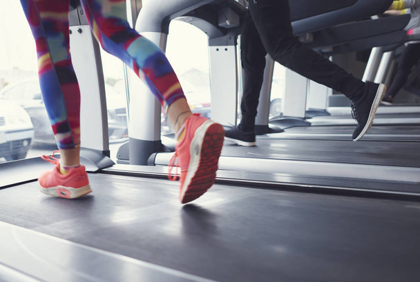 Frau und Mann laufen auf Laufband im Fitnessstudio - Foto, Bild
