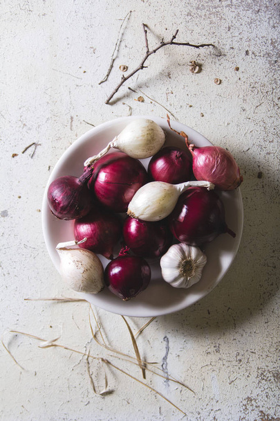 Κόκκινο και λευκό κρεμμύδι βολβοί στο πιάτο την παλιά ξύλινη Χειροποίητη πίνακα - Φωτογραφία, εικόνα