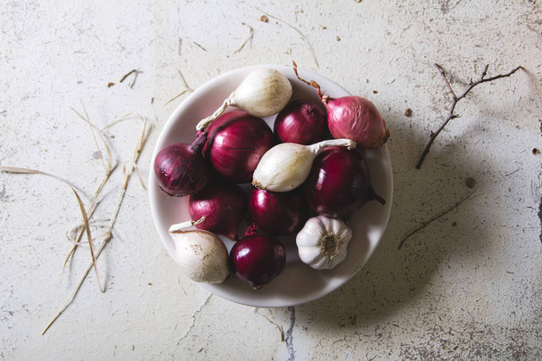 Κόκκινο και λευκό κρεμμύδι βολβοί στο πιάτο την παλιά ξύλινη Χειροποίητη πίνακα - Φωτογραφία, εικόνα