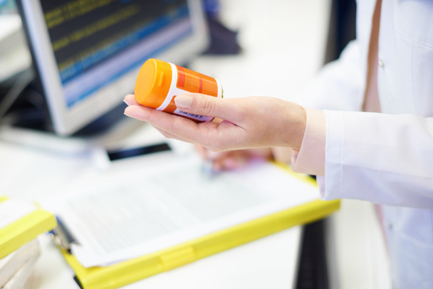Фармацевт держит бутылку с таблетками
 - Фото, изображение