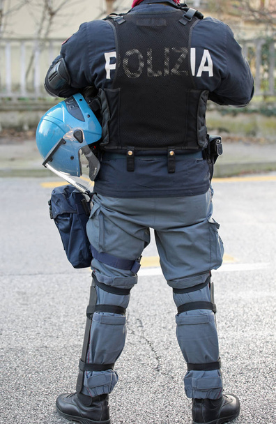 ヘルメットおよびフットボールの試合の前にバトンを持つイタリアの警官 - 写真・画像