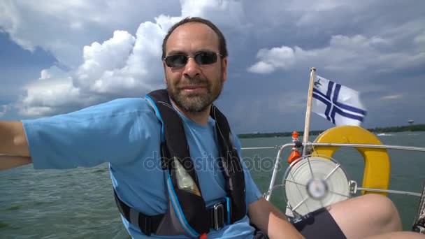 Zeiler regisseert zeilboot in de open zee. - Video