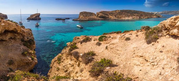 Comino, Malta - A bela Lagoa Azul com água do mar azul-turquesa, iates e turistas snorkel em um dia ensolarado de verão com a ilha de Gozo no fundo
 - Foto, Imagem