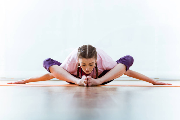 Beautiful young woman practicing yoga at home. - Valokuva, kuva