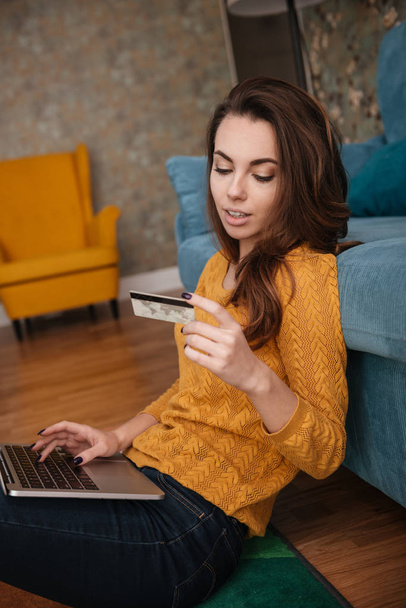 Portrait of a woman shopping on line holding credit card - Foto, afbeelding