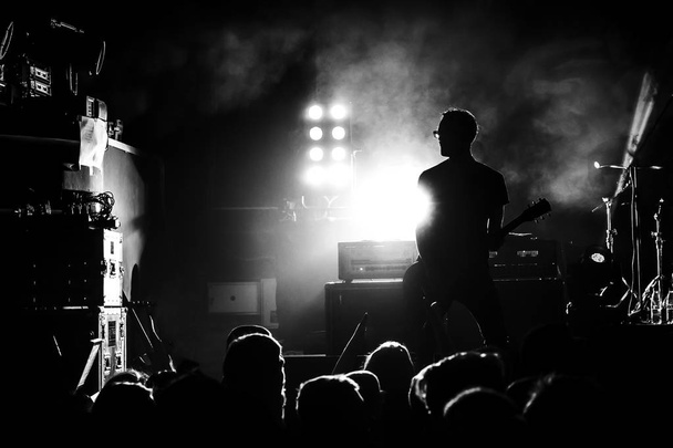 silhouette of guitar player in action on stage - Foto, Imagem
