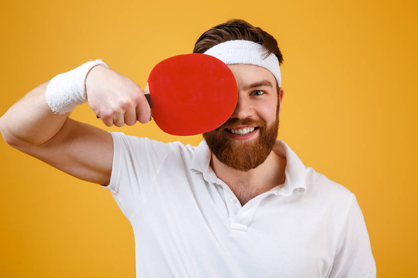 Cheerful young sportsman holding racket for table tennis. - Foto, afbeelding