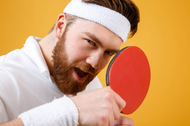 Attractive young sportsman holding racket for table tennis. - Фото, изображение