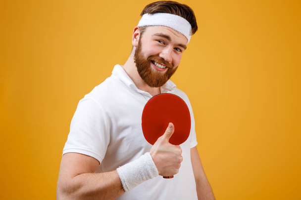Sportsman holding racket for table tennis showing thumbs up gesture. - Fotó, kép