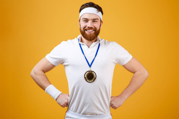 Happy young sportsman with medal looking at camera. - Foto, imagen