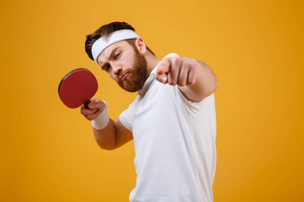 Young sportsman holding racket for table tennis while pointing. - Фото, зображення