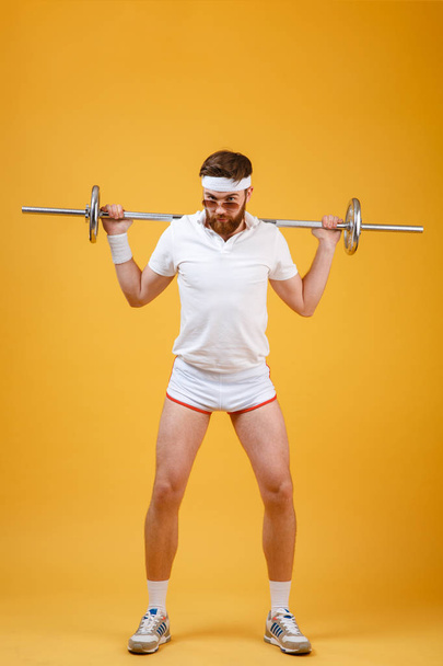 Full length portrait of a man athlete exercising with barbell - Zdjęcie, obraz