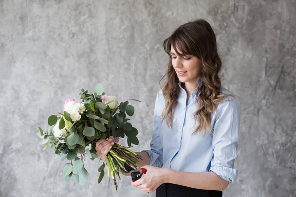 Ανθοπωλείο στο χώρο εργασίας: όμορφη νεαρή γυναίκα κάνει μόδα σύγχρονες Ανθοδετικές διαφορετικά λουλούδια - Φωτογραφία, εικόνα