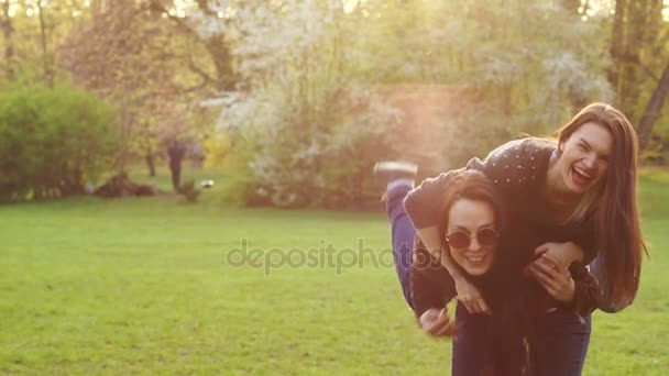 Two young brunette relaxing in spring Park. - Materiał filmowy, wideo