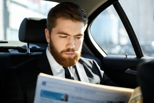 Концентрированный бизнесмен, читающий газету
 - Фото, изображение