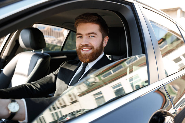 Side view of Smiling business man driving car - Foto, immagini