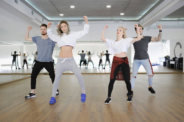 Skupina mladých moderních tanečníků tančí v ateliéru - Fotografie, Obrázek