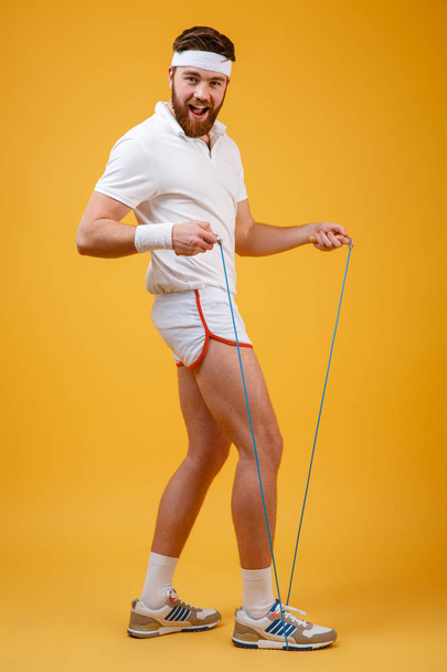 Cheerful young sportsman holding skipping rope - Fotoğraf, Görsel
