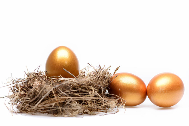 huevos tradicionales pintados en color dorado dentro del nido - Foto, Imagen