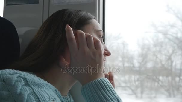 Молода жінка дивиться на вікно під час їзди на поїзді. Профіль привабливої дівчини, що подорожує залізницею. Повільний рух крупним планом
 - Кадри, відео