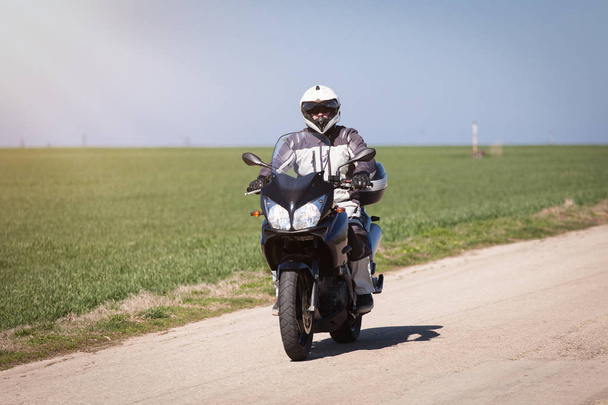 Um motociclista numa mota. Dirigir a estrada vazia em uma viagem de passeio de moto
 - Foto, Imagem