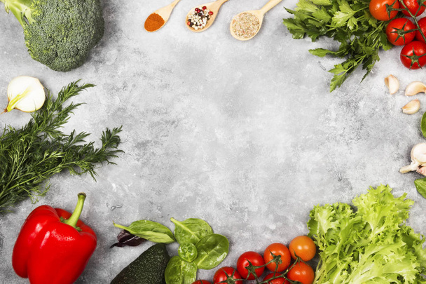 Assortment of fresh vegetables (pepper, cherry tomatoes, onions, garlic, broccoli, avocado, spinach, parsley, fennel) and spices on a light background. Top view, copy space. Food background - Foto, afbeelding