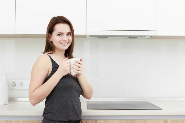 young woman With black hairdrinking coffee in the kitchen - Foto, immagini