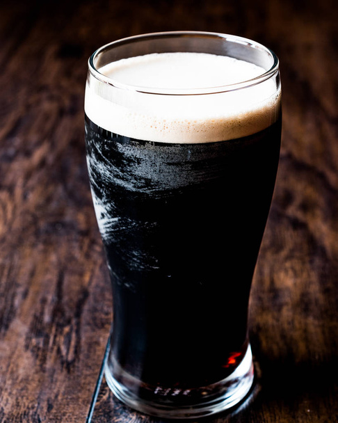 Dark Beer on wooden surface. - Photo, image