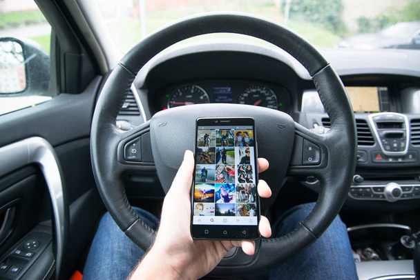 Driver holding smartphone with Instagram application - Foto, imagen