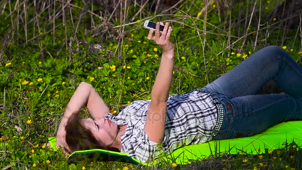 公園で携帯電話で自分の写真を撮る女の子 - 映像、動画