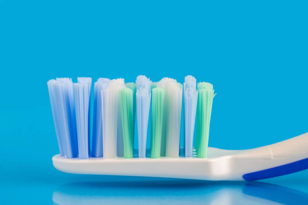 Testa spazzolino da denti su sfondo blu, macro immagine
 - Foto, immagini