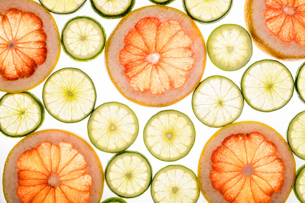 Bright lime and grapefruit slices on white - Foto, afbeelding