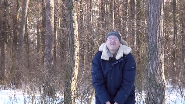 Mann mittleren Alters, der Schnee nimmt und ihn mit einem lächelnden glücklichen Gesicht in Zeitlupe hochwirft - Filmmaterial, Video