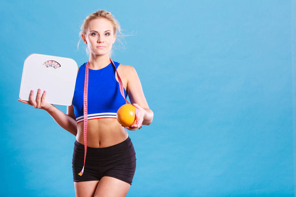 Fit woman holds weight scale grapefruit - Photo, image
