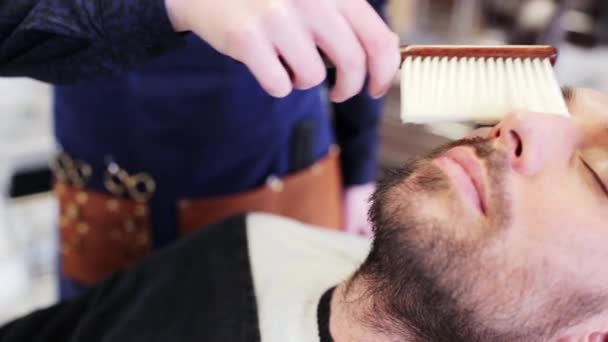 barber cleaning male face with brush at shop - Materiaali, video
