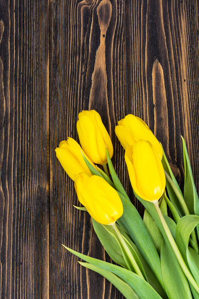 Yellow tulips on a wooden background - Foto, Imagen