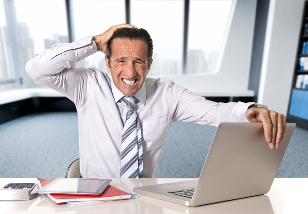 verzweifelter leitender Geschäftsmann in der Krise arbeitet unter Druck am Computer-Laptop am Schreibtisch  - Foto, Bild